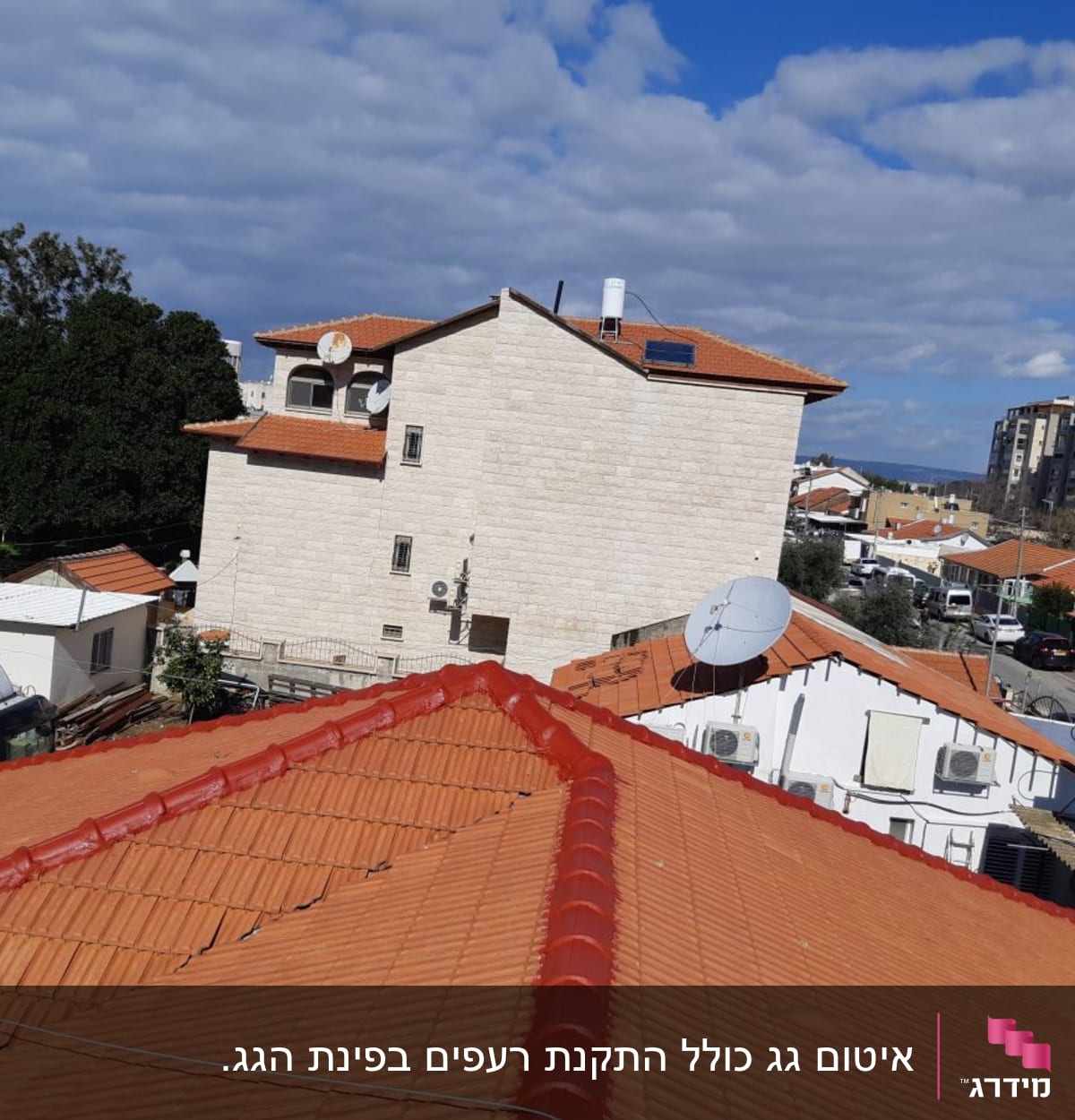 גגות רעפים אדומים עם אנטנות וצלחות לוויין